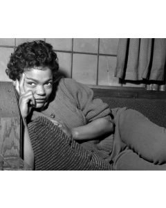 Eartha Kitt listens to a reporter's question as she relaxes backstage, 1958